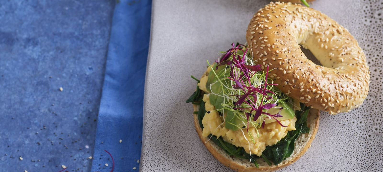 Bagels com ovos mexidos, abacate e espinafres